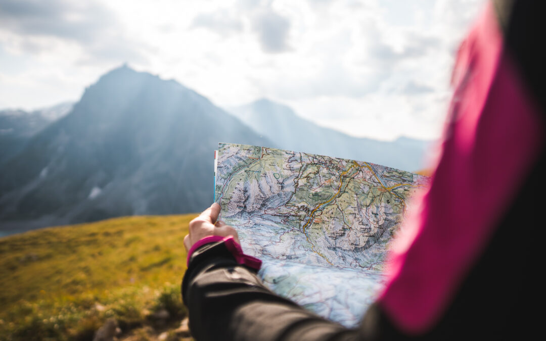 woman holding map looking at mountains